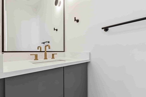 A bathroom with a white sink and a mirror above it.