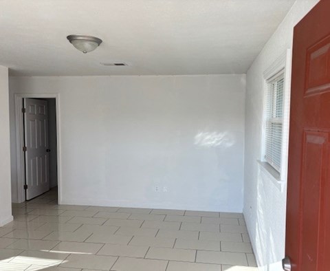 A room with white walls and a red door.