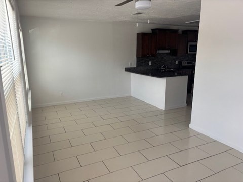 A kitchen area with a counter and a fan.