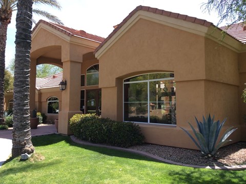A house with a red tile roof and tan stucco exterior.