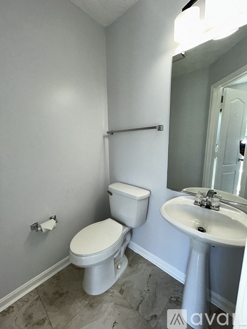 A white toilet and sink in a bathroom.