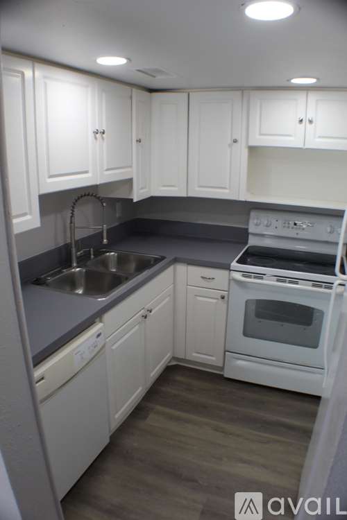 A kitchen with white cabinets and a stove top oven.