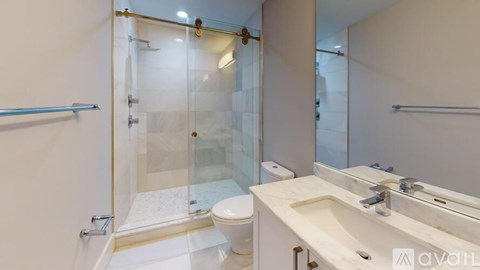 A bathroom with a toilet, sink, and shower.