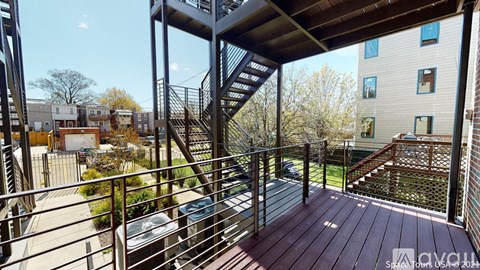 A balcony with a staircase leading to a building.
