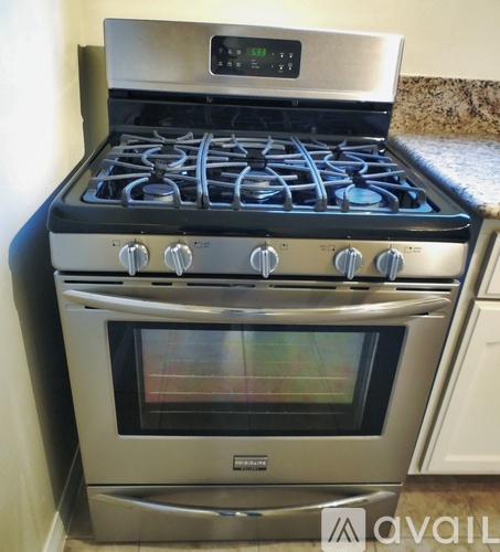A stainless steel oven with a digital clock on top of a stove.