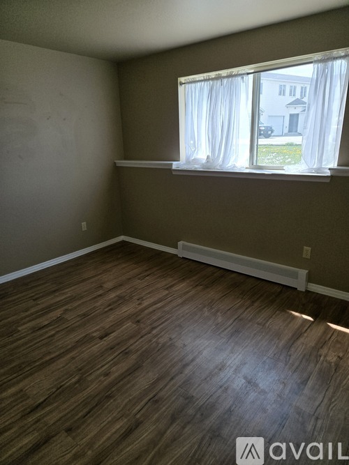 A room with a carpeted floor and a window.