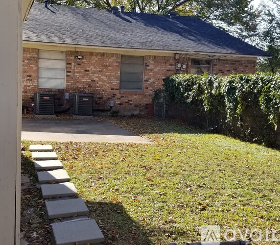 A house with a brick exterior and two air conditioning units.