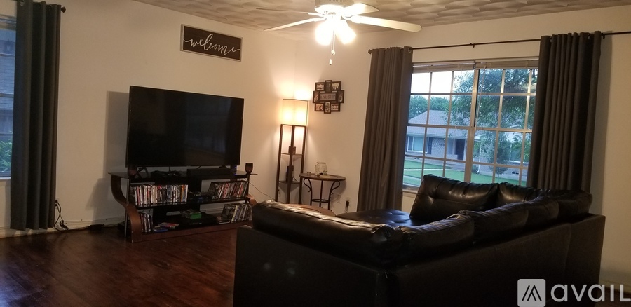 A living room with a black couch and a television.