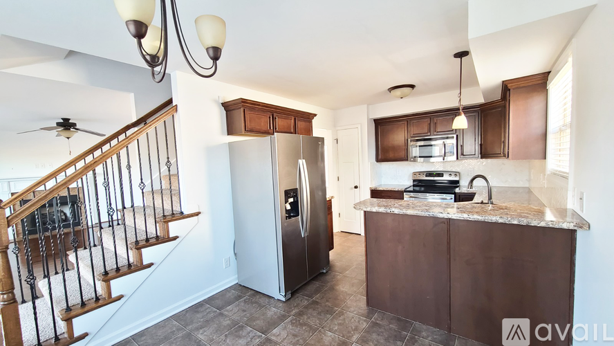 A kitchen with a refrigerator, microwave, and sink is available for rent.