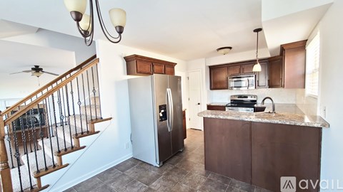 A kitchen with a refrigerator, microwave, and sink is available for rent.