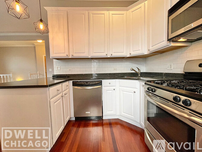 A kitchen with white cabinets and a stainless steel dishwasher and oven.