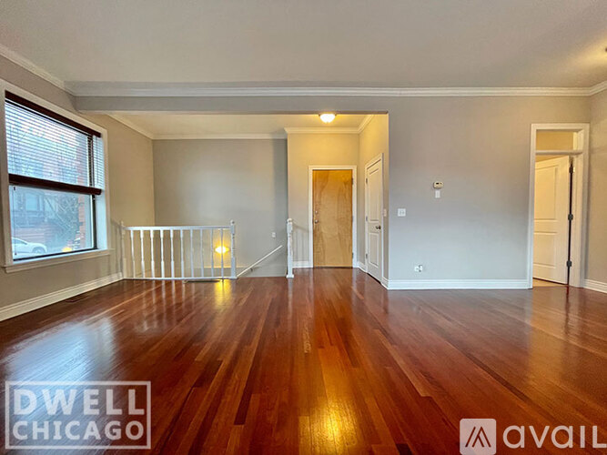 A spacious room with wooden floors and white walls.