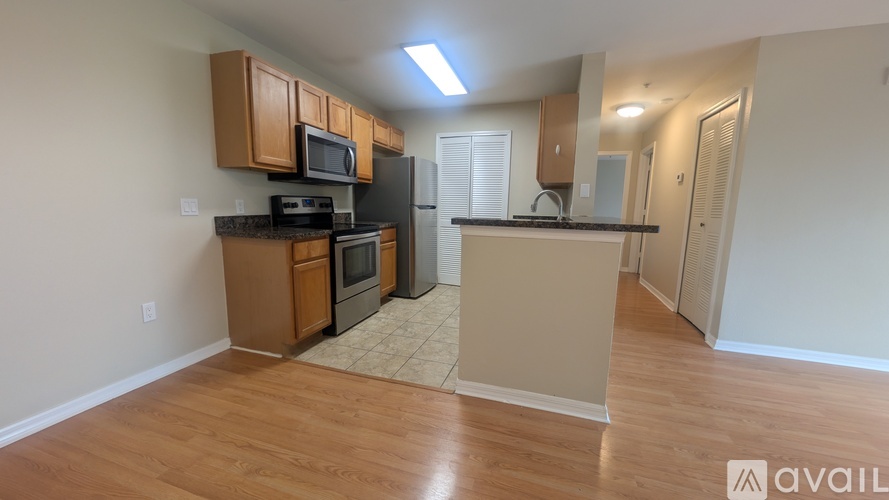A kitchen with wooden cabinets and a black refrigerator.
