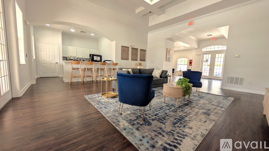 A living room with a blue rug and a blue sofa.