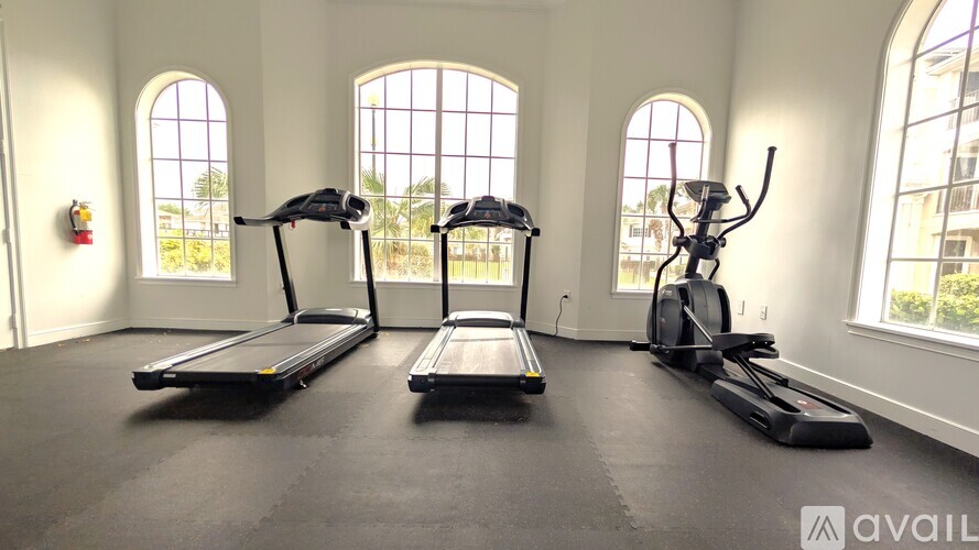 A gym with treadmills, elliptical machines, and a weight machine.