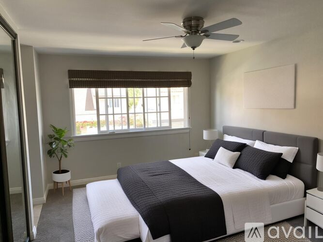 A bedroom with a large bed and a ceiling fan.