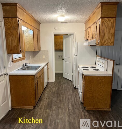 A kitchen with wooden cabinets and a white fridge.
