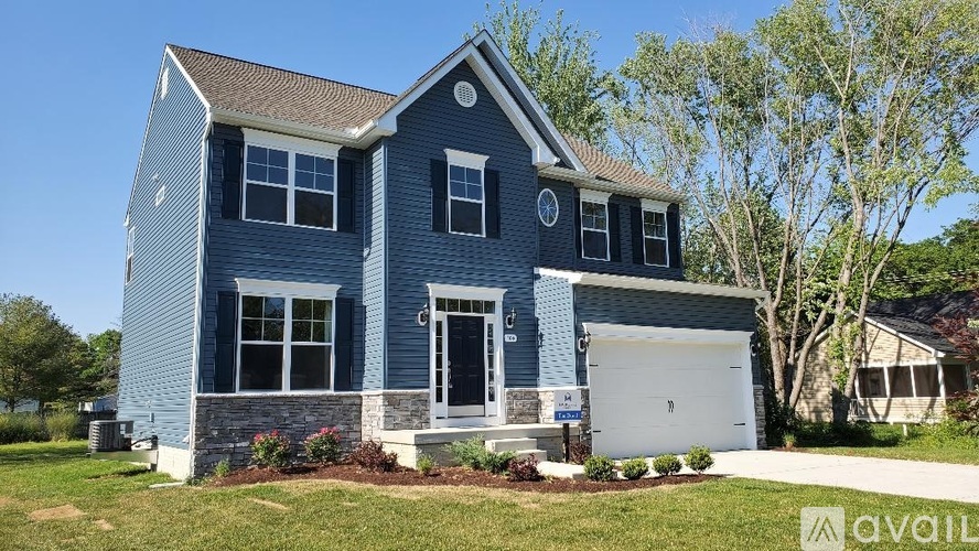 A blue house with a white garage door and a sign that says "available".