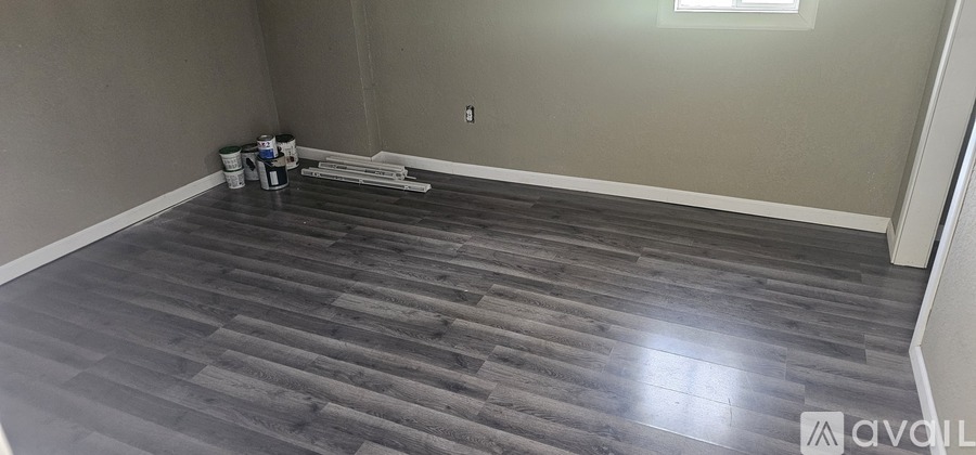 A room with wooden flooring and a window.