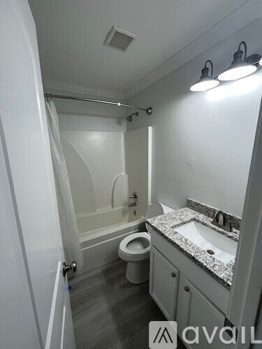 A bathroom with a toilet, sink, and shower.