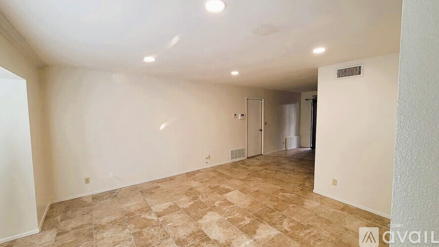 A room with beige tiled flooring and white walls is available for rent.