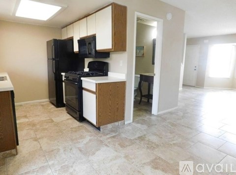 A kitchen with black appliances and wooden cabinets.