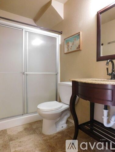 A bathroom with a toilet, sink, and mirror.