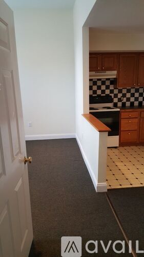 A kitchen with a checkered tile backsplash and wooden cabinets.