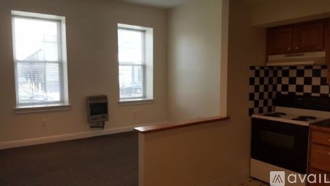 A kitchen with a microwave oven and a checkered tile backsplash.