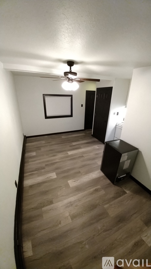 A room with wooden flooring and a ceiling fan.