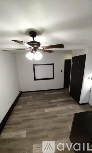A room with a ceiling fan and a picture frame on the wall.