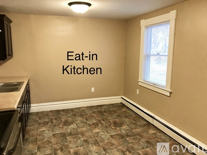 A kitchen with a tile floor and a window.