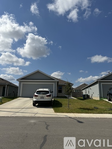 A car is parked in front of a house with a garage.