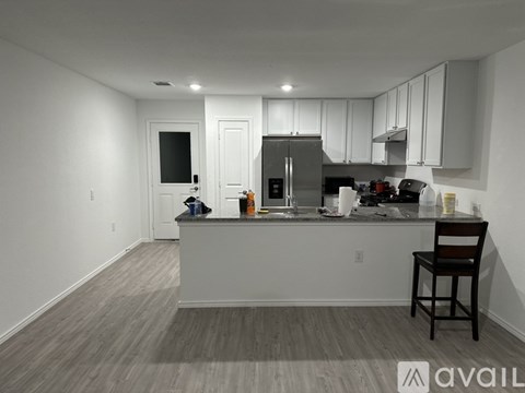 A kitchen with a bar stool and a counter with a few items on it.