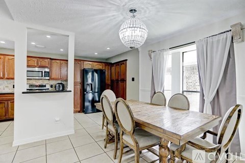 A dining room with a table and chairs.