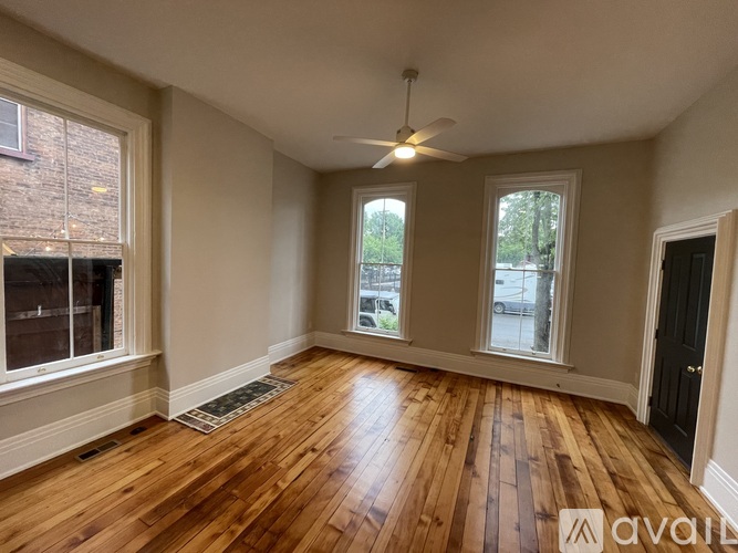 A room with wooden floors and a ceiling fan.