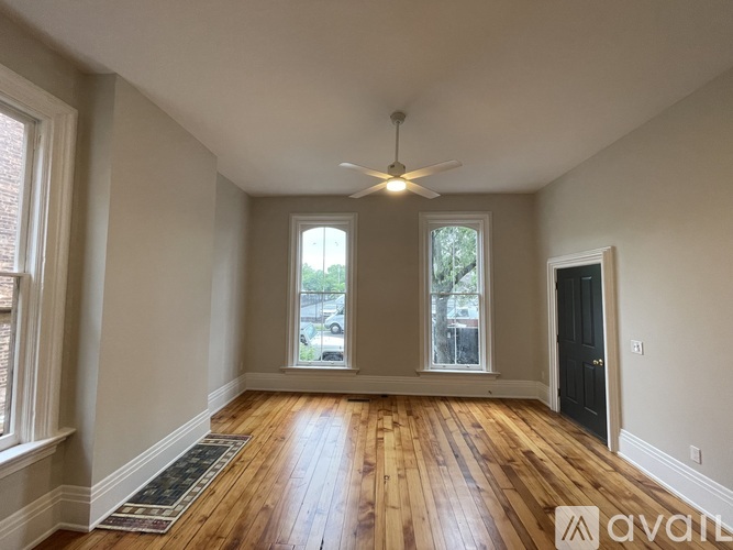 A room with wooden floors and a ceiling fan.