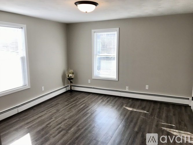 A room with a window and a wooden floor.