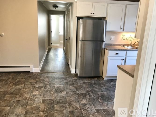 A kitchen with a refrigerator and cabinets.
