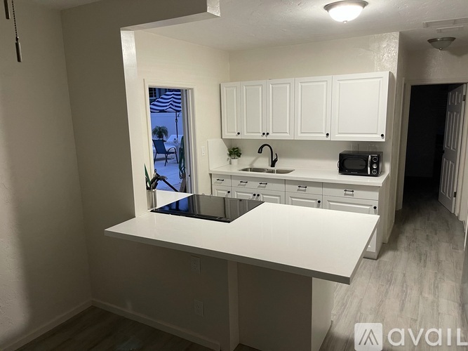 A kitchen with white cabinets and a large island.