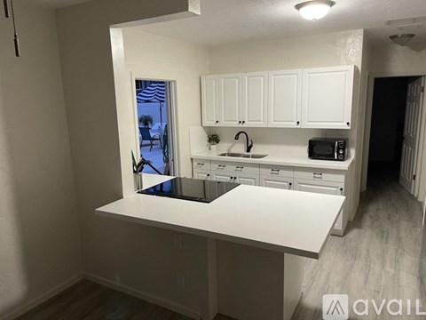 A kitchen with white cabinets and a large island.