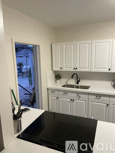 A kitchen with white cabinets and a black stove top.