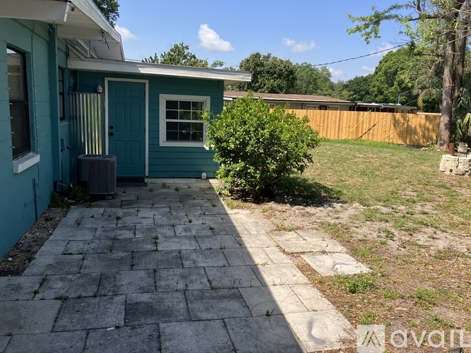 A blue house with a grey stone walkway in front.