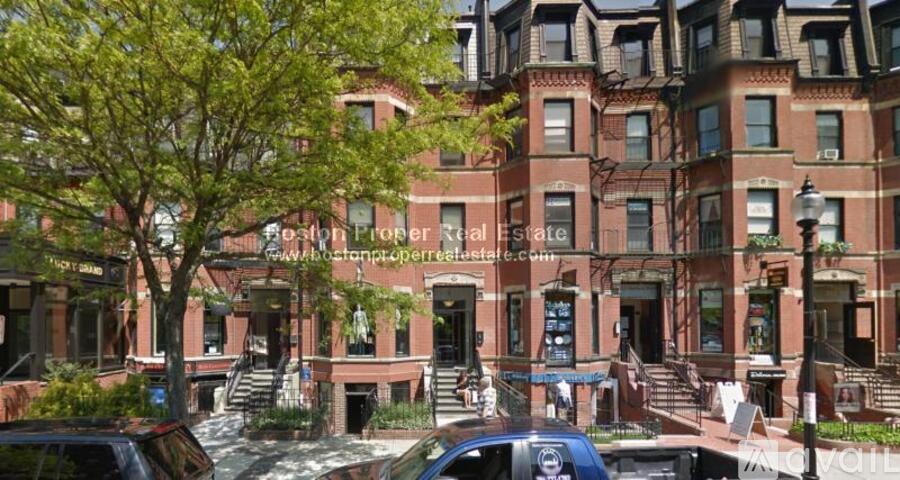 A red brick building with a tree in front of it.