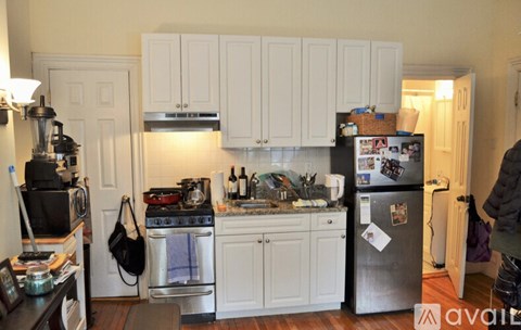 A kitchen with white cabinets and a black stove top.
