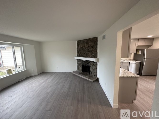 A living room with a fireplace and wood flooring.