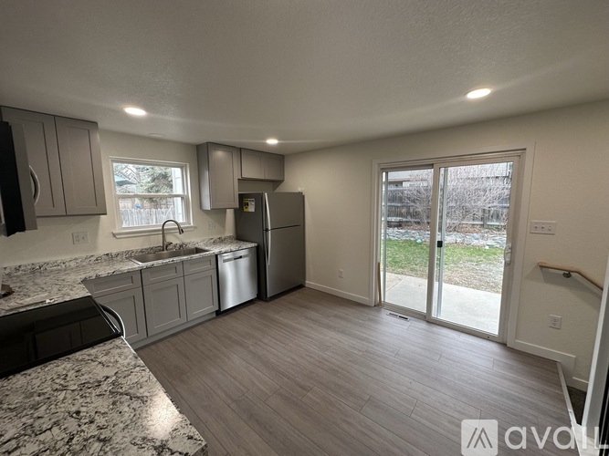 A kitchen with a granite countertop and stainless steel appliances.