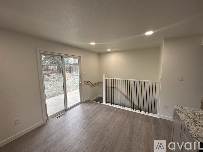 A spacious room with a sliding glass door leading to a backyard.