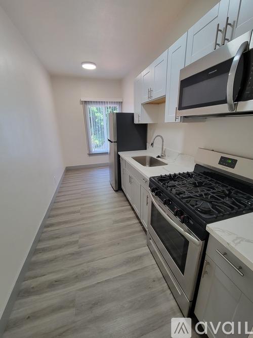 A kitchen with a stove, oven, microwave, and sink.