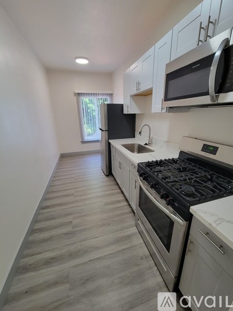 A kitchen with a stove, oven, microwave, and sink.